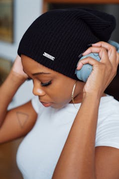 African-Australian woman puts headphones on
