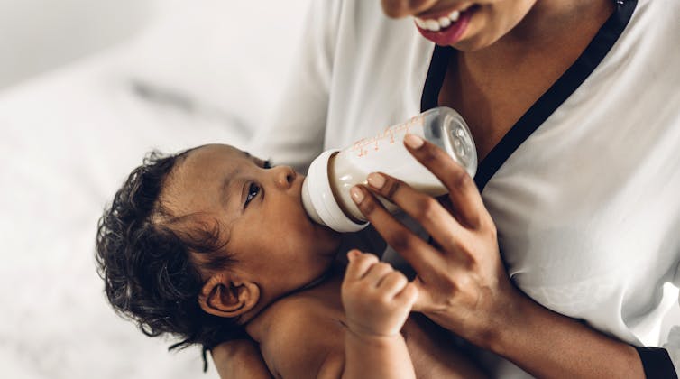 Woman bottle feeding baby