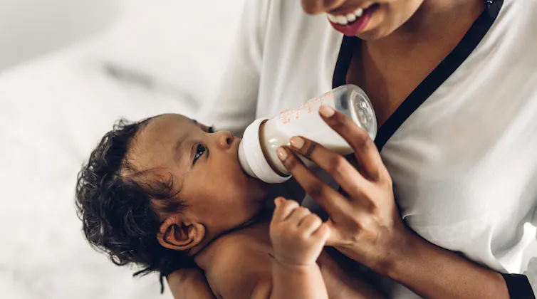 Woman bottle feeding baby