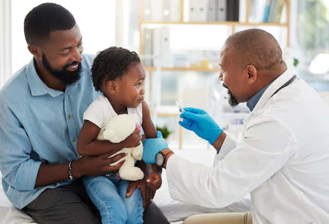 parent holding a child getting vaccinated