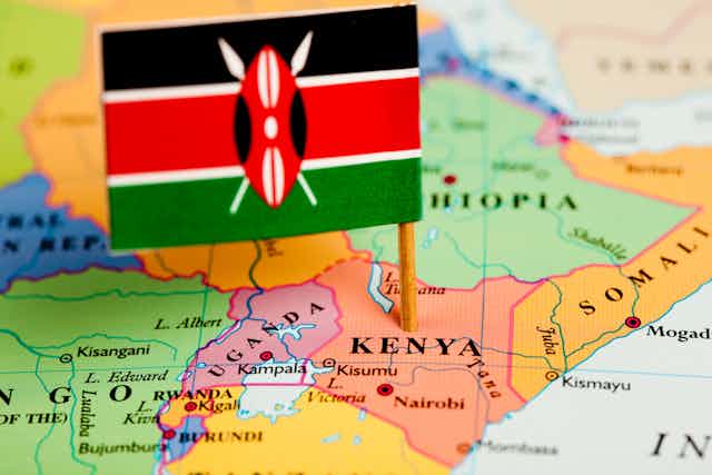 A map of Kenya with a small flag on it that is black, white, red and green