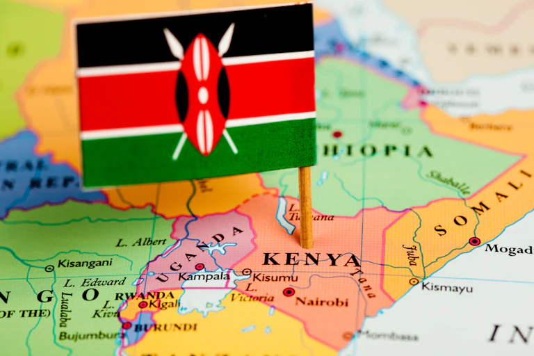 A map of Kenya with a small flag on it that is black, white, red and green