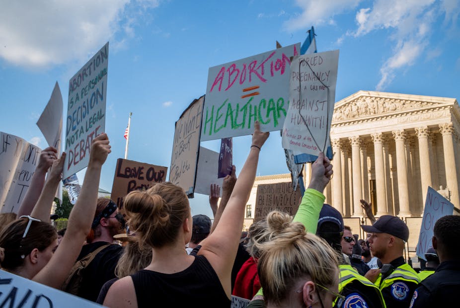 A horde of people, holding signs that call for abortion rights above the heads, protest in from of the U.S. Supreme Court.
