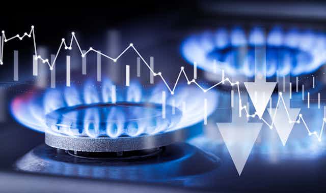 Dos quemadores de gas y un gráfico, concepto de reducción de precios.