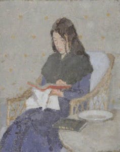 A seated woman with a shawl reading a book.