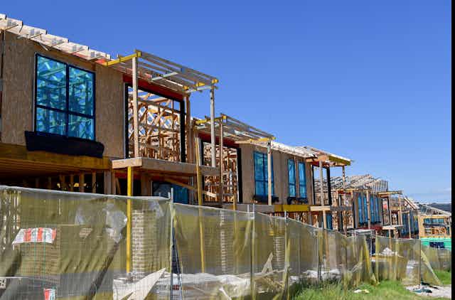 Row of timber-framed houses under construction