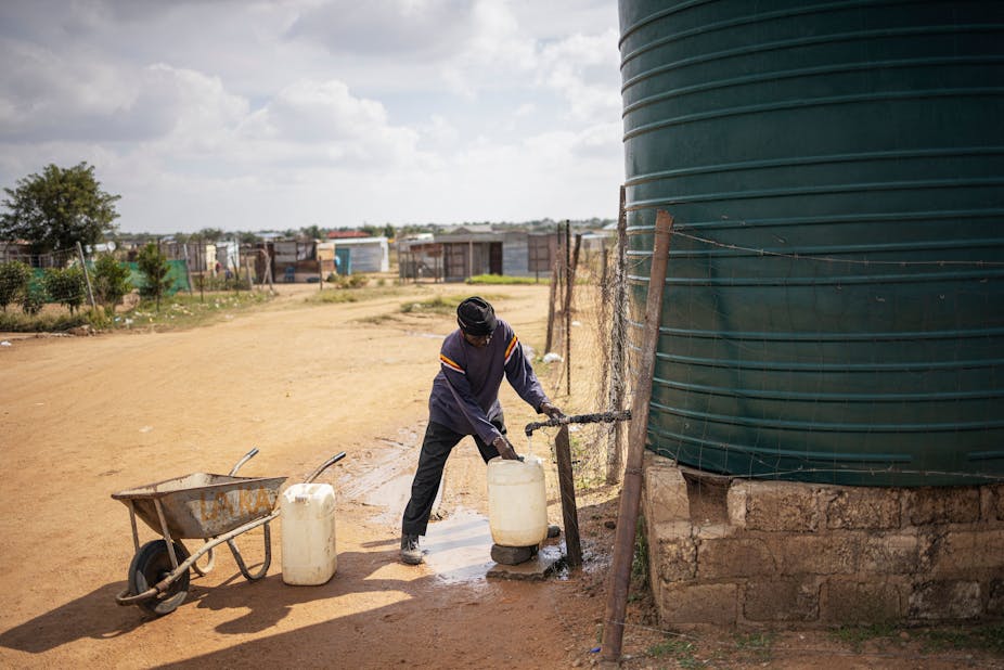 A man collecting water from a large container 