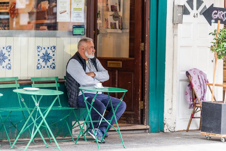 Oldish man sitting outside a cafe
