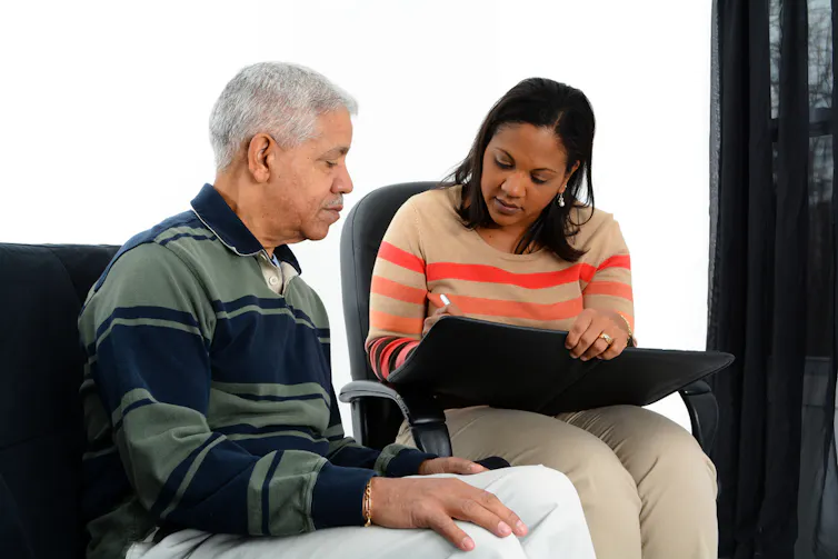 Caseworker helping an elderly man.