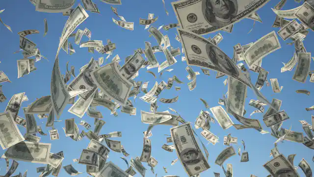 100 US Dollar, bills flying on blue sky background.