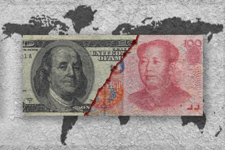 Full-colour US dollar and Chinese yuan notes torn in half and pictured beside each other over a grey map of the world.