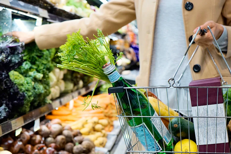 Une femme en train de faire ses courses au rayon fruits et légumes.
