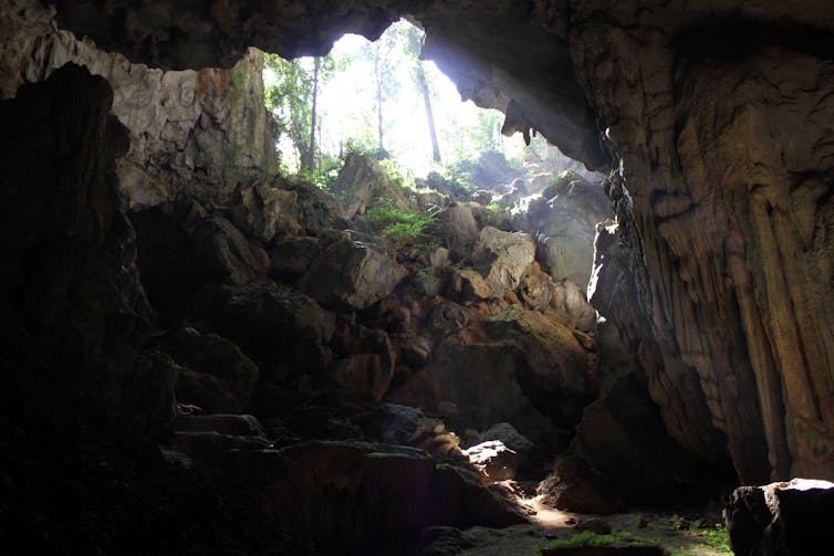 A photo from inside a cave, looking up a rocky slope to daylight outside.