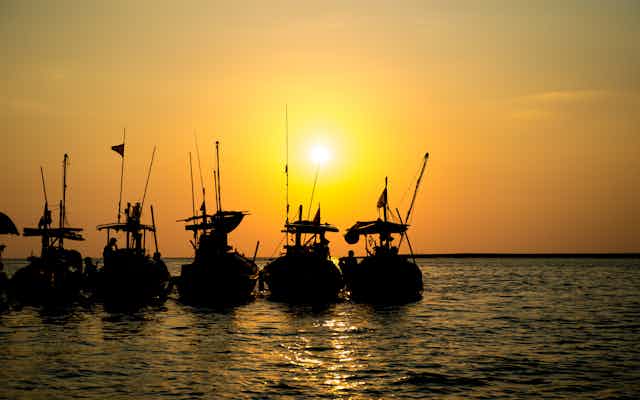 Fishing boats in a row at sunset