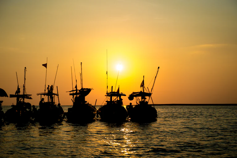 Fishing boats in a row at sunset