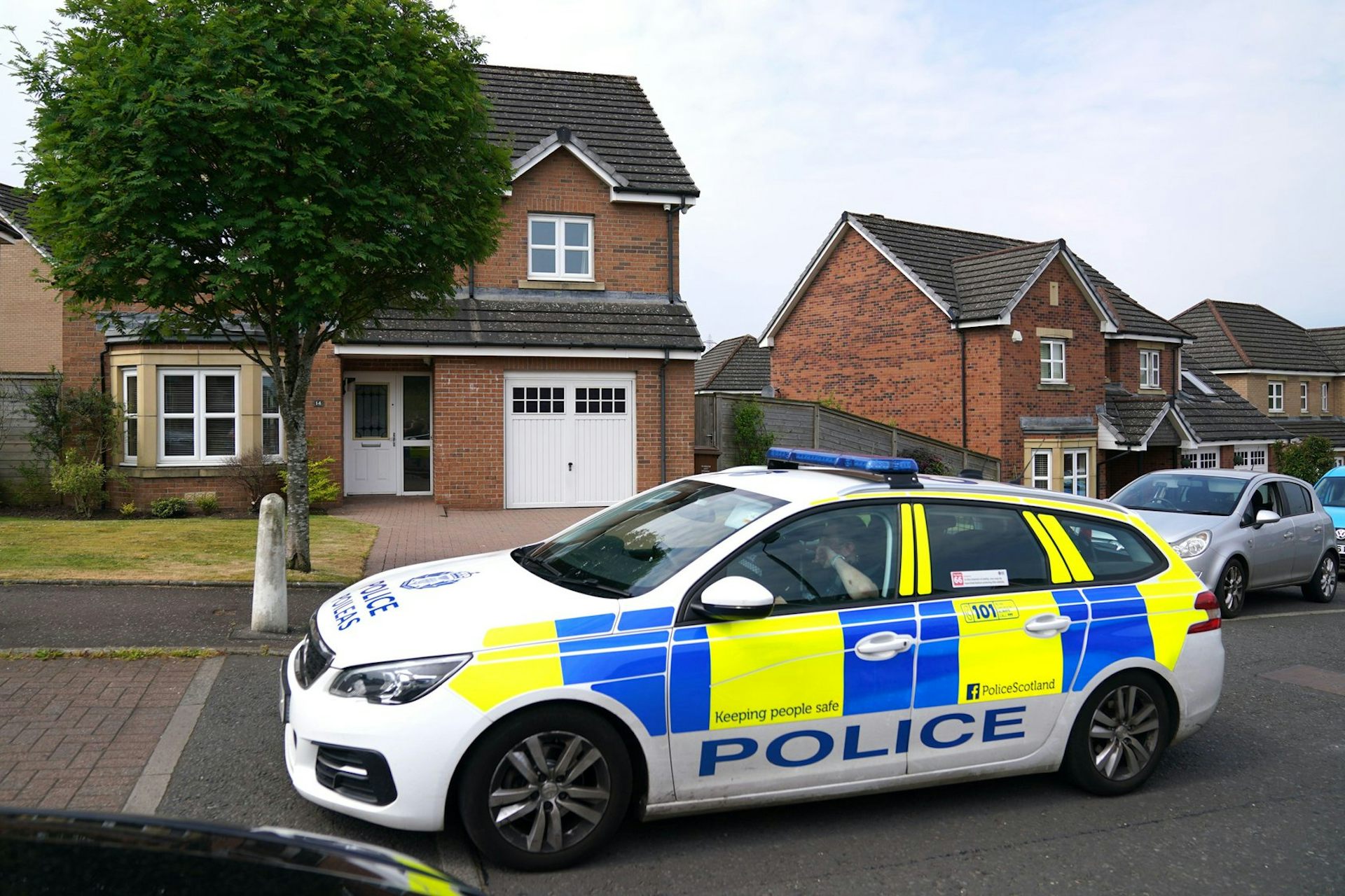 A police car parked on a suburban street.