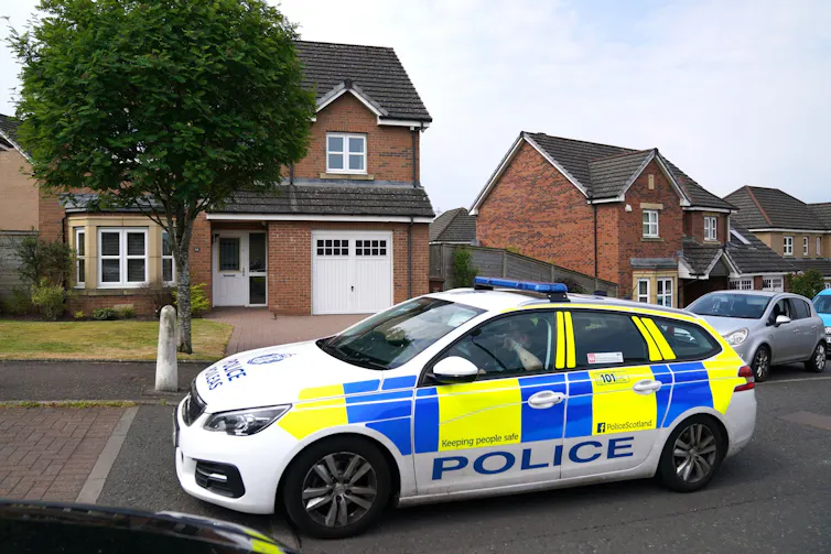 A police car parked on a suburban street.