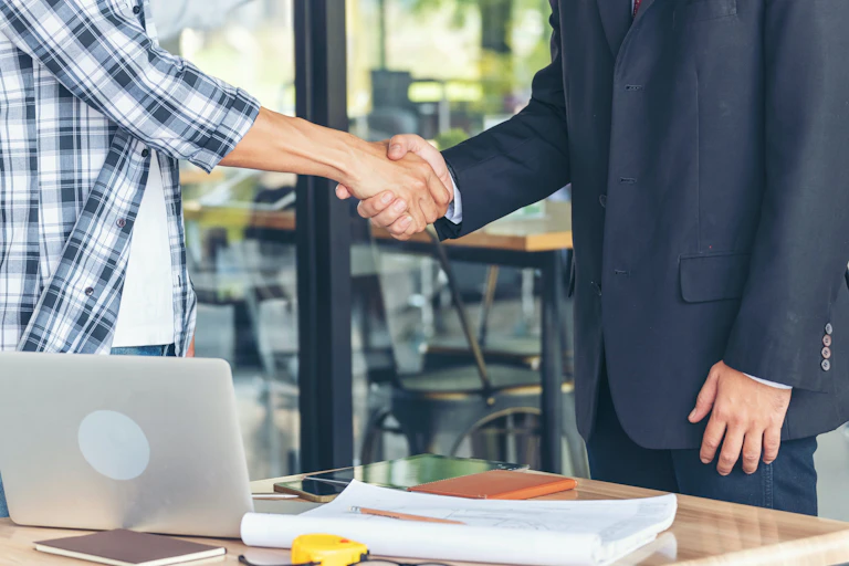 Empresario y emprendedor se dan la mano.