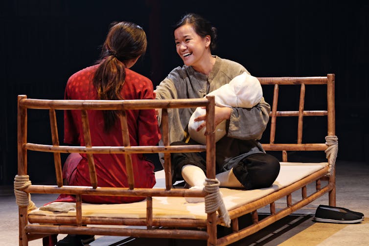 Two women on a bed.