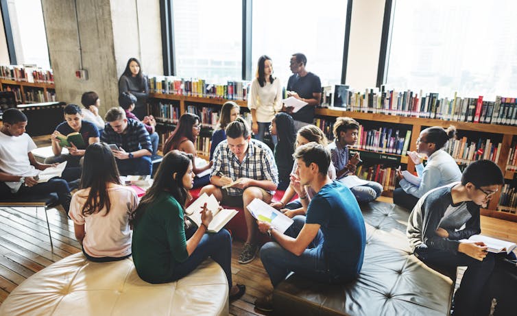 Students sit and talk in a library.