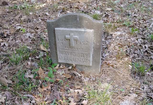 Gravestone surrounded by leaves reading 'Mr. Woody D. Blountson.'