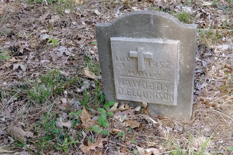 Gravestone surrounded by leaves reading 'Mr. Woody D. Blountson.'