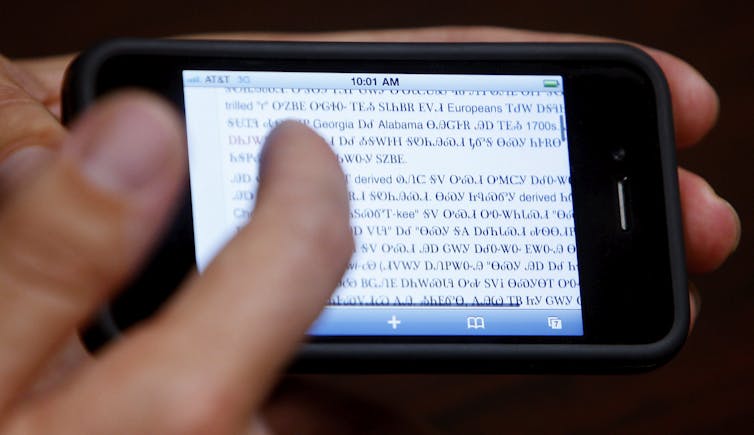 A close up of a smartphone with a person's hand and text on the screen