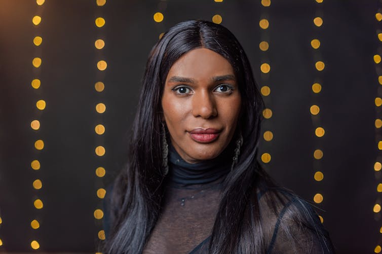 stock photo of a transgender person looking at camera with blurred light background