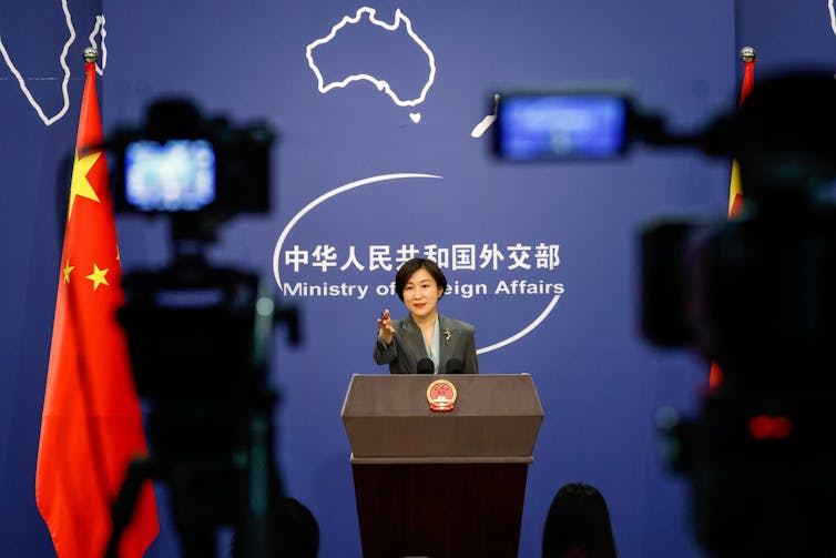 A Chinese foreign ministry official points at cameras while speaking at a podium, February 2023.