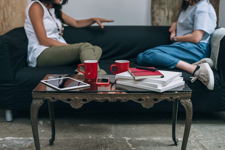 Two women having a conversation on the sofa.