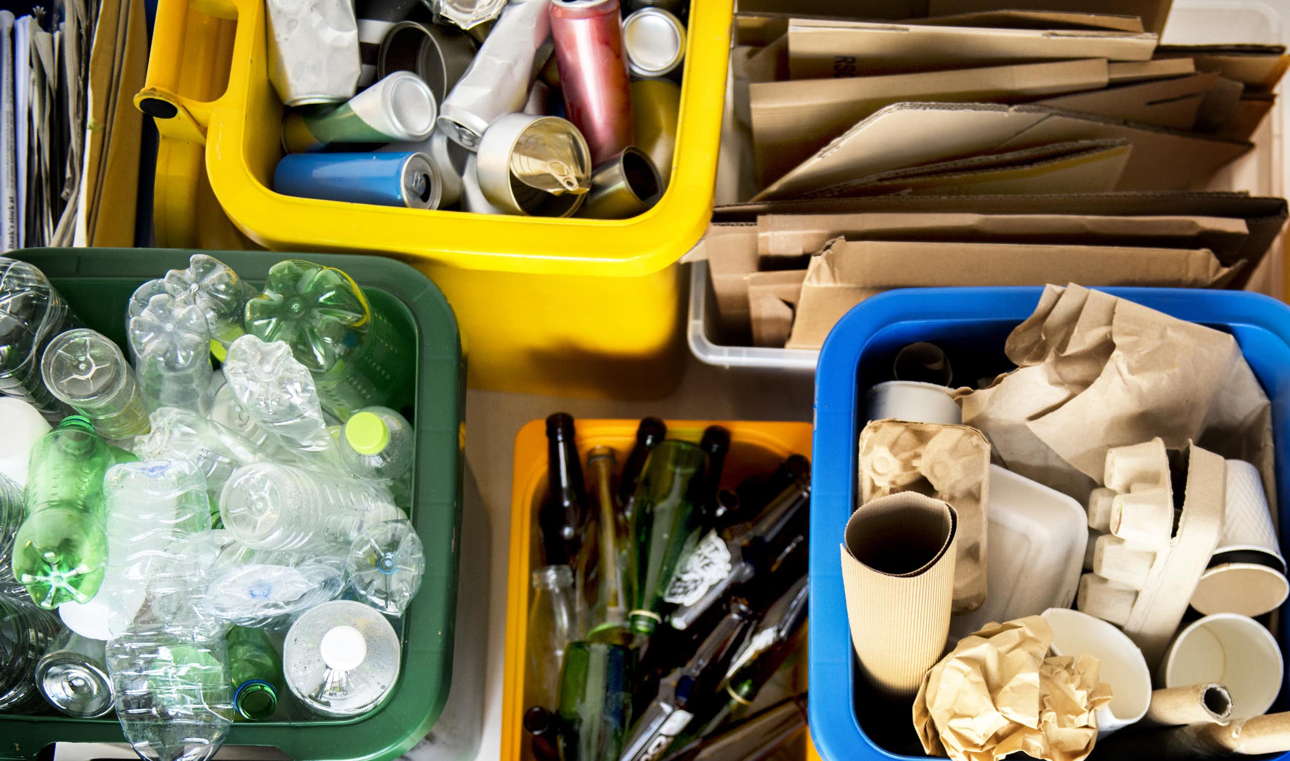 Des bacs à recyclage contenant du plastique, des cannettes, du verre et du carton