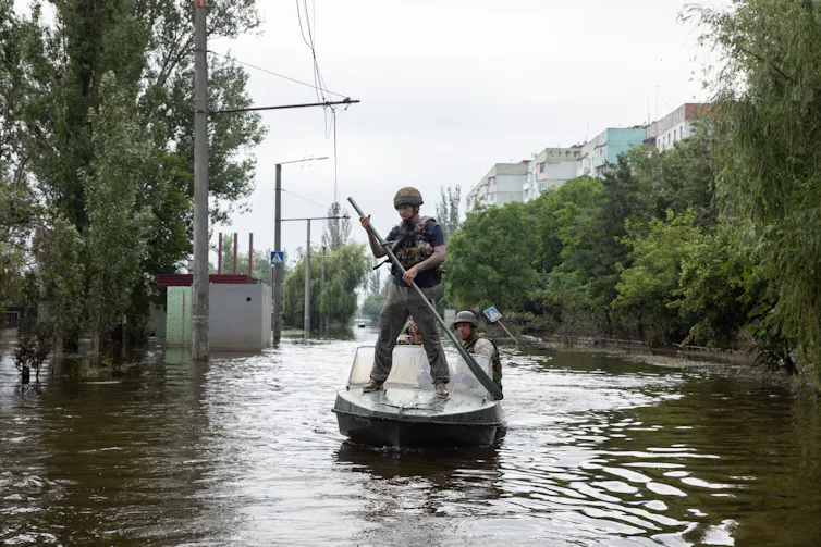 A volunteer paddles through flooding in Kherson after the dam was breached.