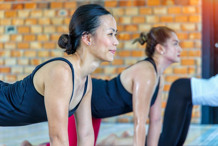 Women in hot yoga studio sweating.