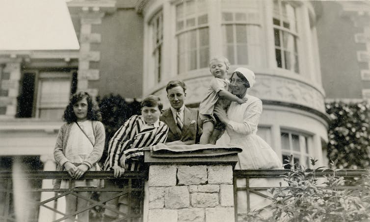 Black and white photograph of Leonora Carrington with her brothers Gerard and Arthur, her uncle George Moorhead and nanny Mary Kavanaugh at Hazelwood Hall.