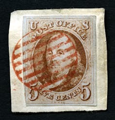A postage stamp featuring an image of Benjamin Franklin, a red cancel mark, and the words 'U.S. Post Office, five cents.'
