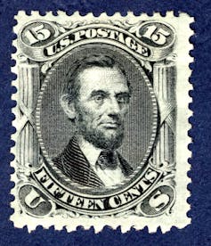 Accompanied by the words 'U.S. Postage' and 'fifteen cents,' a portrait of Abraham Lincoln appears squarely in the center of the stamp.