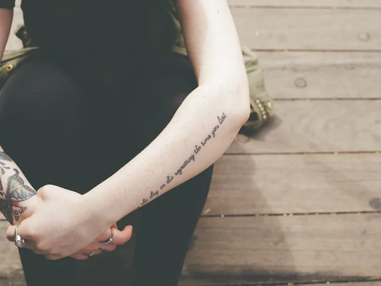 Woman with tattoos crosses her arms