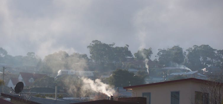 Haze from wood smoke hangs over suburban houses