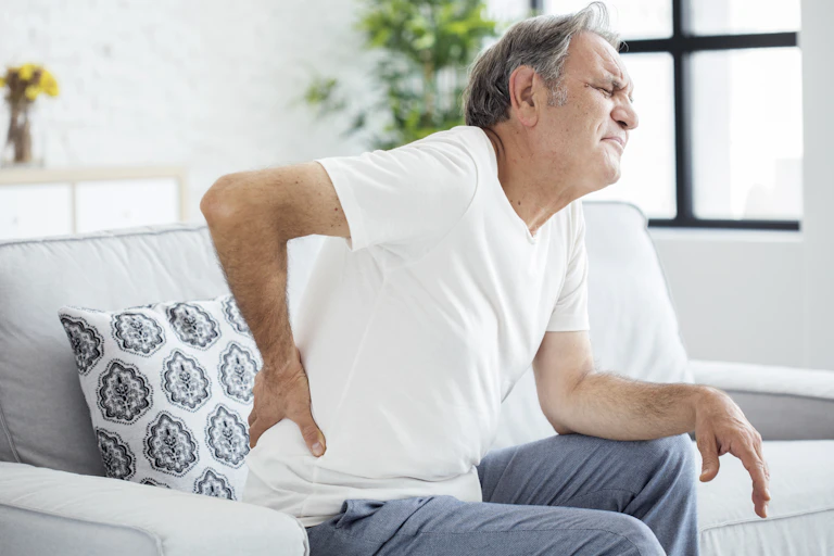 Man in pain holds in lower back