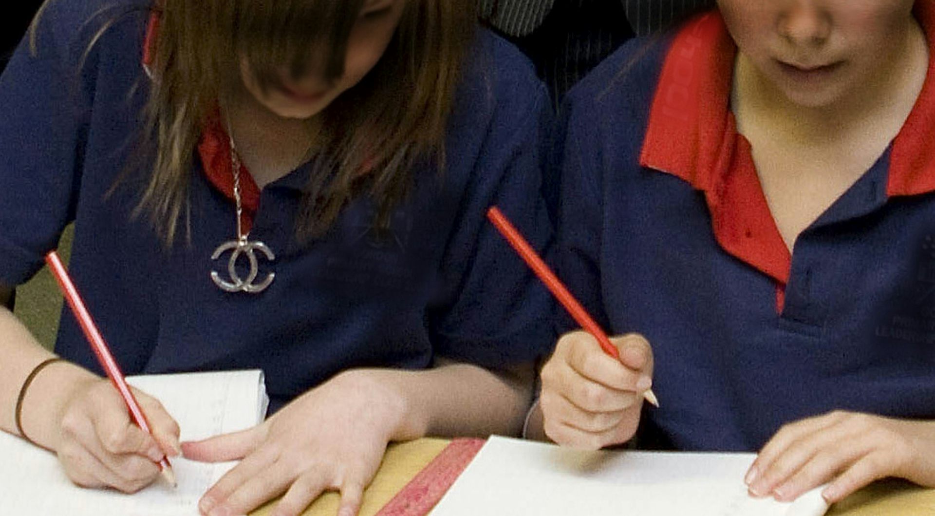 Two students write on work sheets.