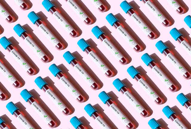 repeating pattern of blood vials marked 'COVID-19'