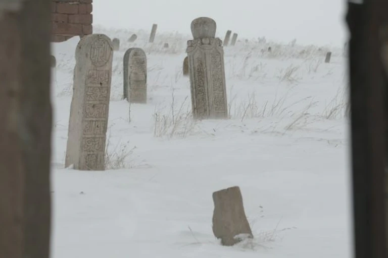 Famine graves in a still from the documentary, set in a snowy scene.
