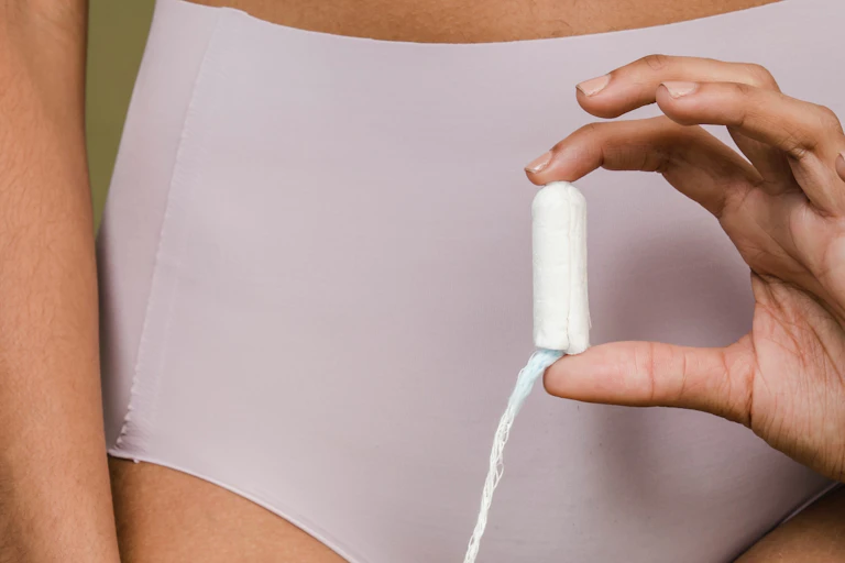 Woman in underwear holding a tampon