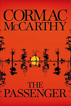 A bright red book cover of Cormac McCarthy's The Passenger