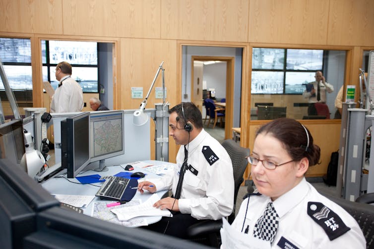 Two police officers at a desk.