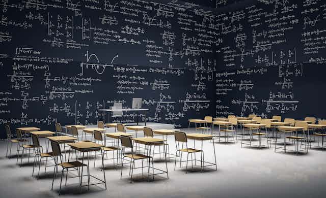 Un aula con paredes que son pizarras llenas de problemas matemáticos.
