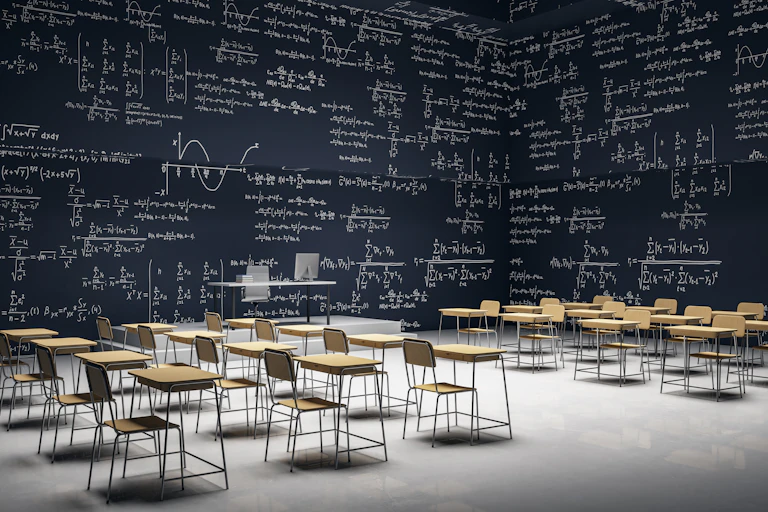 Un aula con paredes que son pizarras llenas de problemas matemáticos.