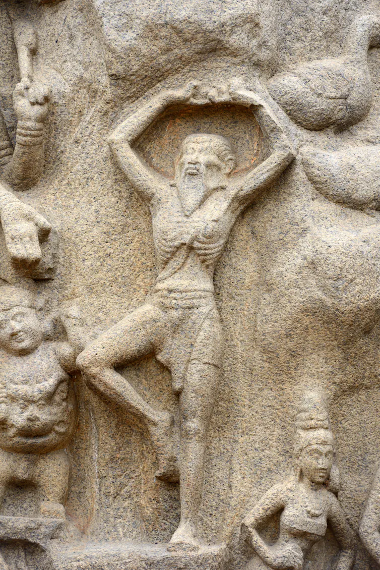 Rock relief of a bearded man standing in a yoga position