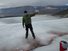 Man in icy landscape holding scientific sample