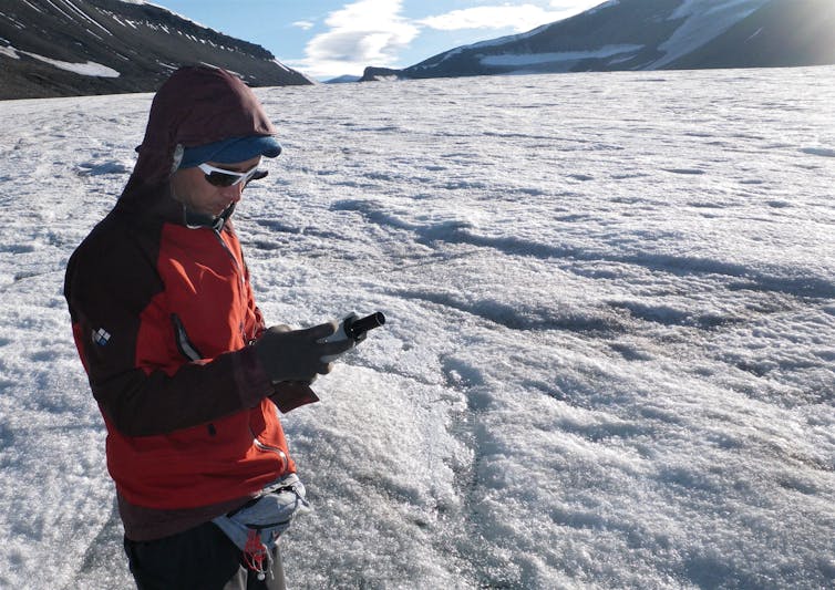 Scientist takes a reading in snowy Arctic landscape